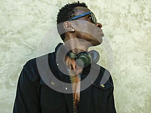 Young handsome and attractive athletic afro American man in open black denim jacket posing in cool attitude in fashion beauty