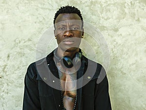 Young handsome and attractive athletic afro American man in open black denim jacket posing in cool attitude in fashion beauty