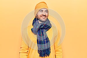 Young handsome bald man wearing winter clothes looking to side, relax profile pose with natural face and confident smile