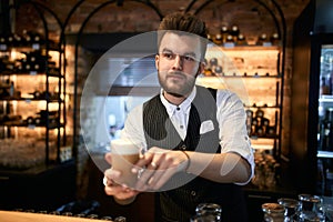 Young handsome barmen giving beverage to clients