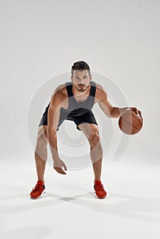 Young handsome basketball player leading game ball