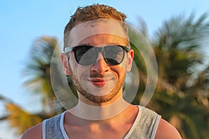 Young handsome bearded guy in black sunglasses close up