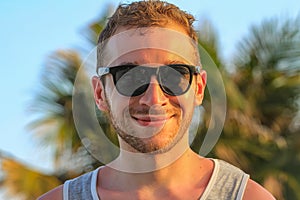 Young handsome bearded guy in black sunglasses close up