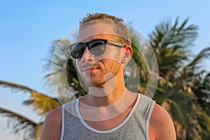 Young handsome bearded guy in black sunglasses close up