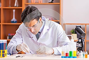 Young handsome biochemist working in the lab