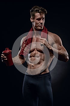 Young handsome bodybuilder drinking water