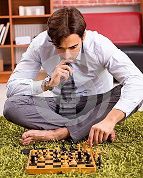 Young handsome boss playing chess during break