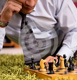 Young handsome boss playing chess during break