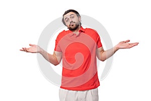 young handsome brunette man in red t-shirt gesturing on white background with copy space