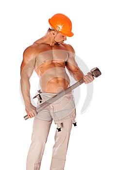 Young and handsome builder with a sledgehammer and