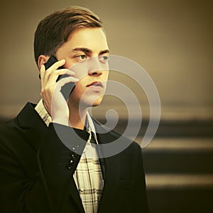 Young handsome business man calling on cell phone on city street