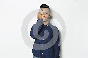 Young handsome business man covering one eye with hand isolated on white background