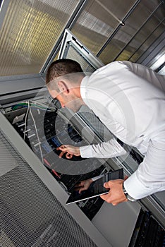 Young handsome business man engeneer in datacenter server room