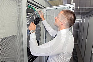 Young handsome business man engeneer in datacenter server room photo