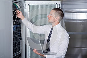 Young handsome business man engeneer in datacenter server room photo