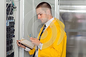 Young handsome business man engeneer in datacenter server room photo