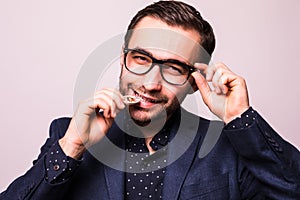 Young handsome business man in glasses bite bitcoin cion isolated on gray background