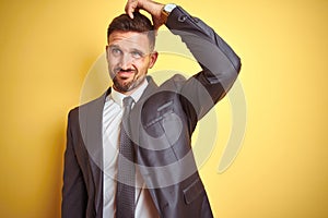 Young handsome business man over yellow isolated background confuse and wonder about question