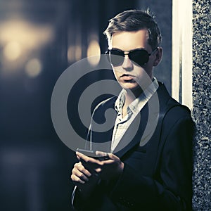 Young handsome business man using smart phone in a night city street