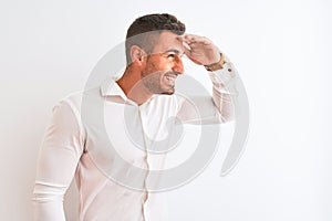 Young handsome business man wearing elegant shirt over  background very happy and smiling looking far away with hand over