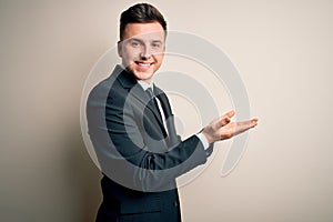 Young handsome business man wearing elegant suit and tie over isolated background pointing aside with hands open palms showing