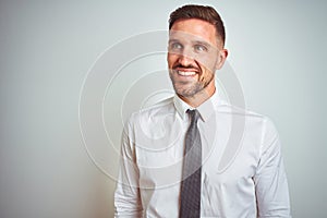 Young handsome business man wearing elegant white shirt over isolated background looking away to side with smile on face, natural