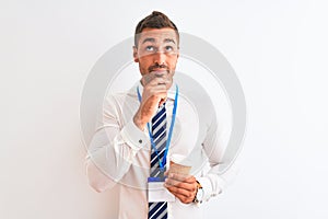 Young handsome business man wearing id pass and drinking coffee over isolated background serious face thinking about question,