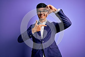 Young handsome business man wearing jacket and glasses over isolated purple background smiling making frame with hands and fingers