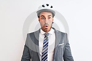 Young handsome business man wearing suit and tie and bike helmet over isolated background afraid and shocked with surprise