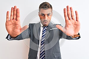 Young handsome business man wearing suit and tie over isolated background doing stop gesture with hands palms, angry and