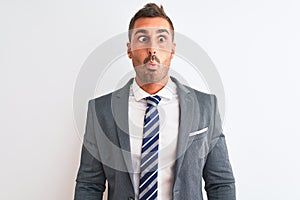 Young handsome business man wearing suit and tie over isolated background making fish face with lips, crazy and comical gesture