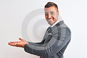 Young handsome business man wearing suit and tie over isolated background pointing aside with hands open palms showing copy space,