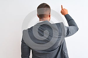 Young handsome business man wearing suit and tie over isolated background Posing backwards pointing ahead with finger hand