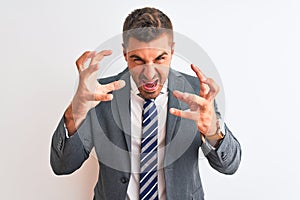 Young handsome business man wearing suit and tie over isolated background Shouting frustrated with rage, hands trying to strangle,
