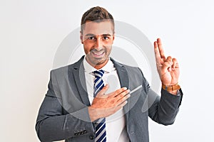 Young handsome business man wearing suit and tie over isolated background smiling swearing with hand on chest and fingers up,