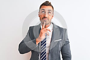 Young handsome business man wearing suit and tie over isolated background Thinking concentrated about doubt with finger on chin