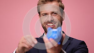 young handsome business man wearing suit and tie on pink background