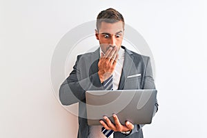 Young handsome business man working using computer laptop over isolated background cover mouth with hand shocked with shame for