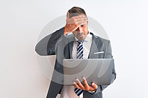 Young handsome business man working using computer laptop over isolated background stressed with hand on head, shocked with shame