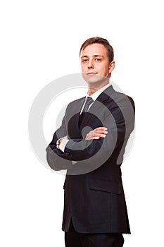 Young handsome businessman in black suit is standing straight with crossed arms, full length portrait isolated on white