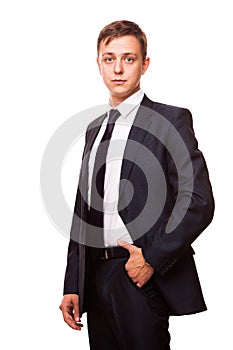 Young handsome businessman in black suit is standing straight, portrait isolated on white background