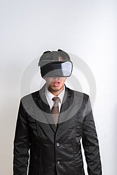 Young handsome businessman in black suit wearing virtual reality