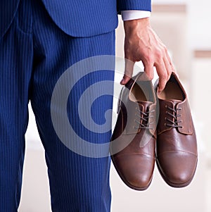 Young handsome businessman choosing shoes at home