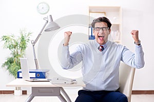 The young handsome businessman employee working in office at desk