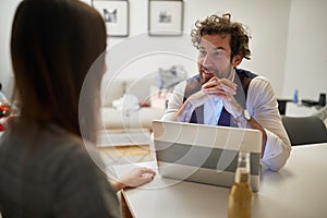 A young handsome businessman at his home office interviewing a young sexy girl for a job. Business, interview, people