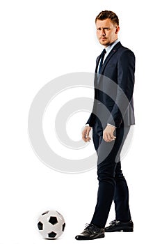 Young handsome businessman manager kicking a soccer ball on white background isolated.