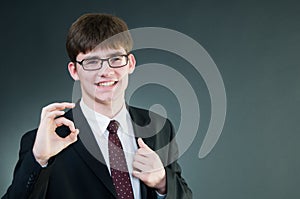 Young handsome businessman showing ok sign