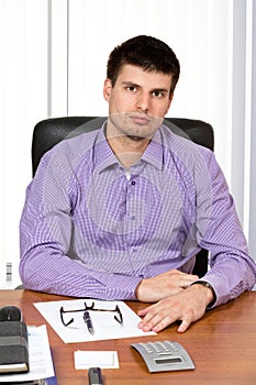 Young handsome businessman sitting at his desk