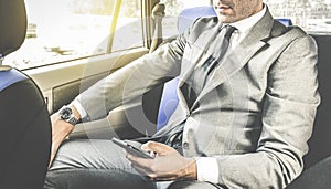 Young handsome businessman sitting in taxi cab with phone photo