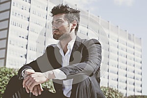 Young and handsome businessman sitting thinking